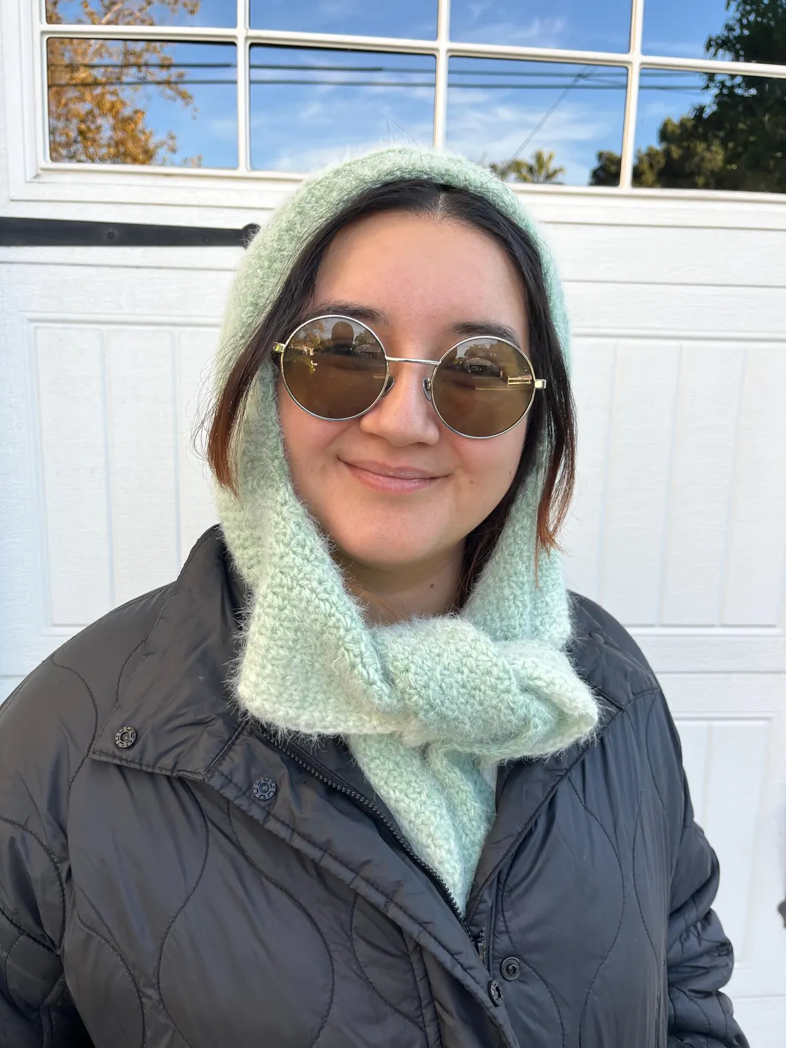 Crocheted Sophie Hood worn by woman outdoors – warm and stylish winter accessory.