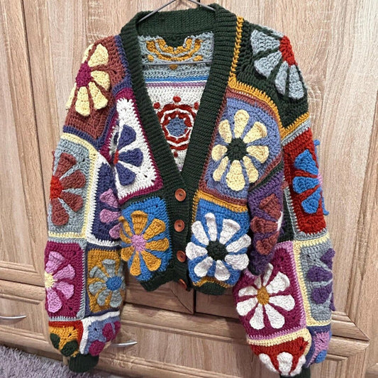 crocheted retro daisy granny square cardigan with floral patterns on a wooden surface