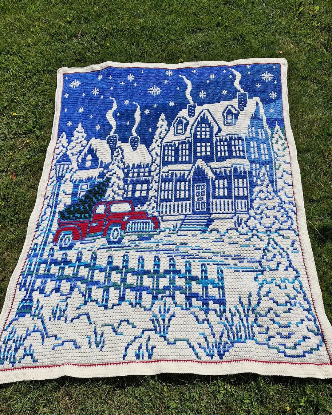 Home for Christmas crochet blanket on green grass outdoors