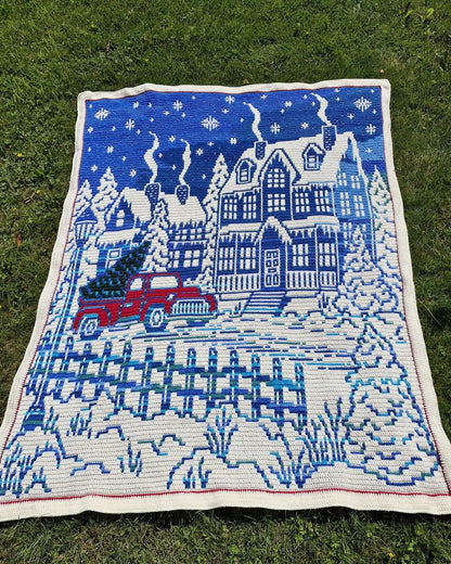 Home for Christmas crochet blanket on green grass outdoors