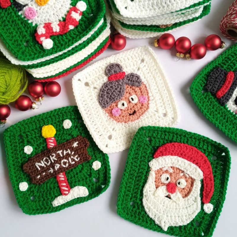 Crocheted Christmas-themed granny squares with Santa Claus, North Pole sign, and reindeer face on a white background.